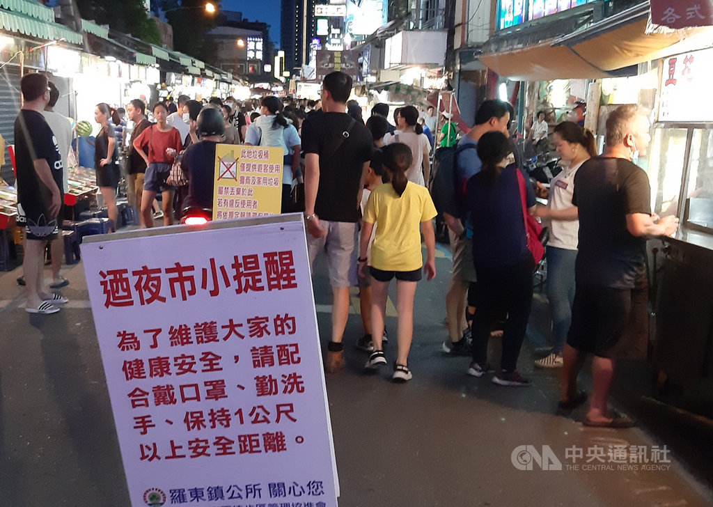 中央流行疫情指揮中心宣布8大場所戴口罩後的首個週末,宜蘭縣羅東鎮公所在夜市出入口放上告示牌,提醒民眾戴起口罩並維持社交距離。中央社記者沈如峰宜蘭縣攝 109年8月8日