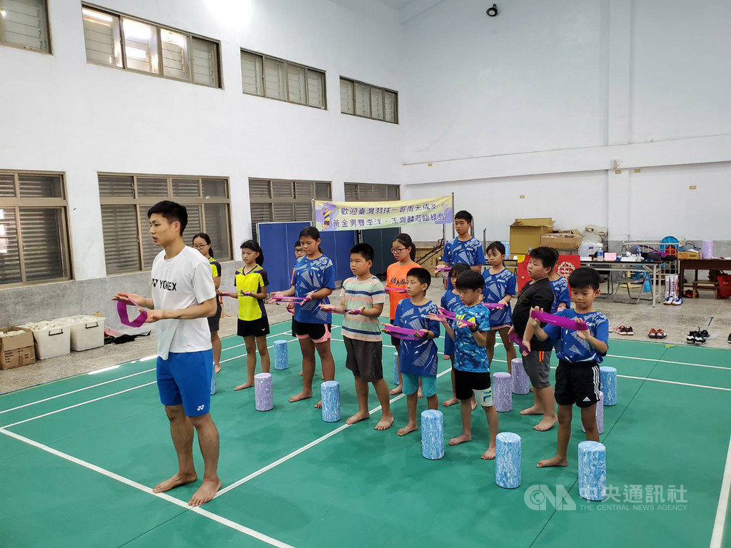 台東縣綠島國小羽球隊將平日練習情況剪輯成短片「羽夢想更近」,盼讓世界看見小球員努力,台灣羽球一哥周天成(左)特地到校指導,以彈力帶訓練小球員的肢體靈活度。(台東縣政府提供)中央社記者李先鳳傳真 109年8月9日