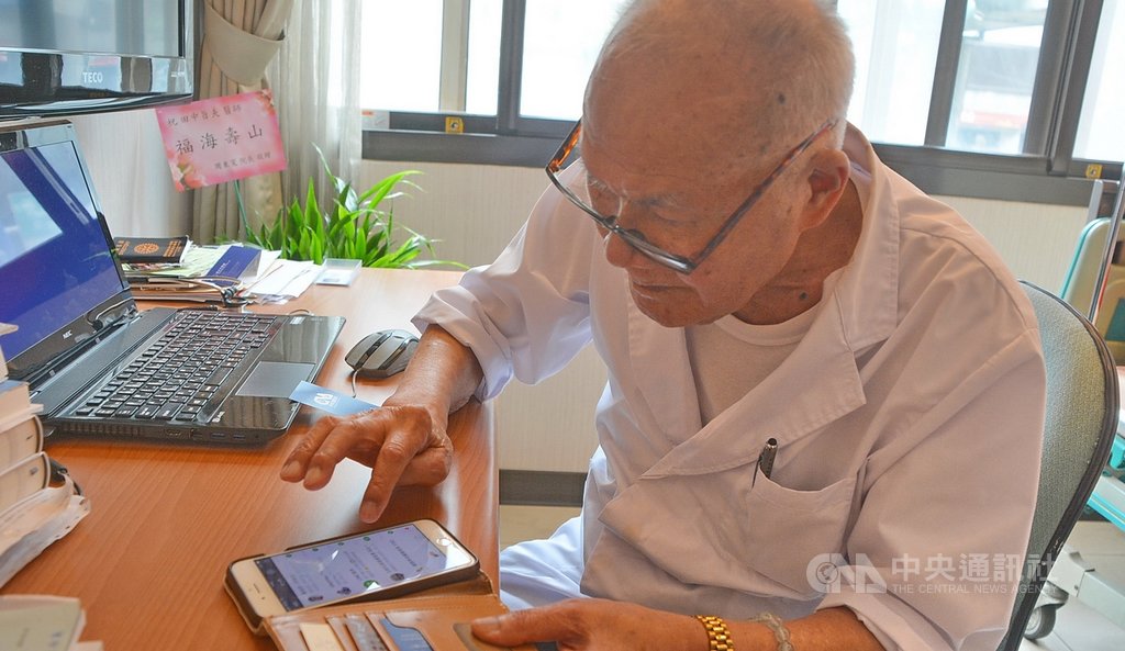 102歲人瑞醫師陳奎村(田中旨夫)仍在診所看診,守護民眾健康,雖然高齡,使用電腦與智慧手機、通訊軟體LINE樣樣行,一點都不輸年輕人。中央社記者黃旭昇新北攝 109年8月9日