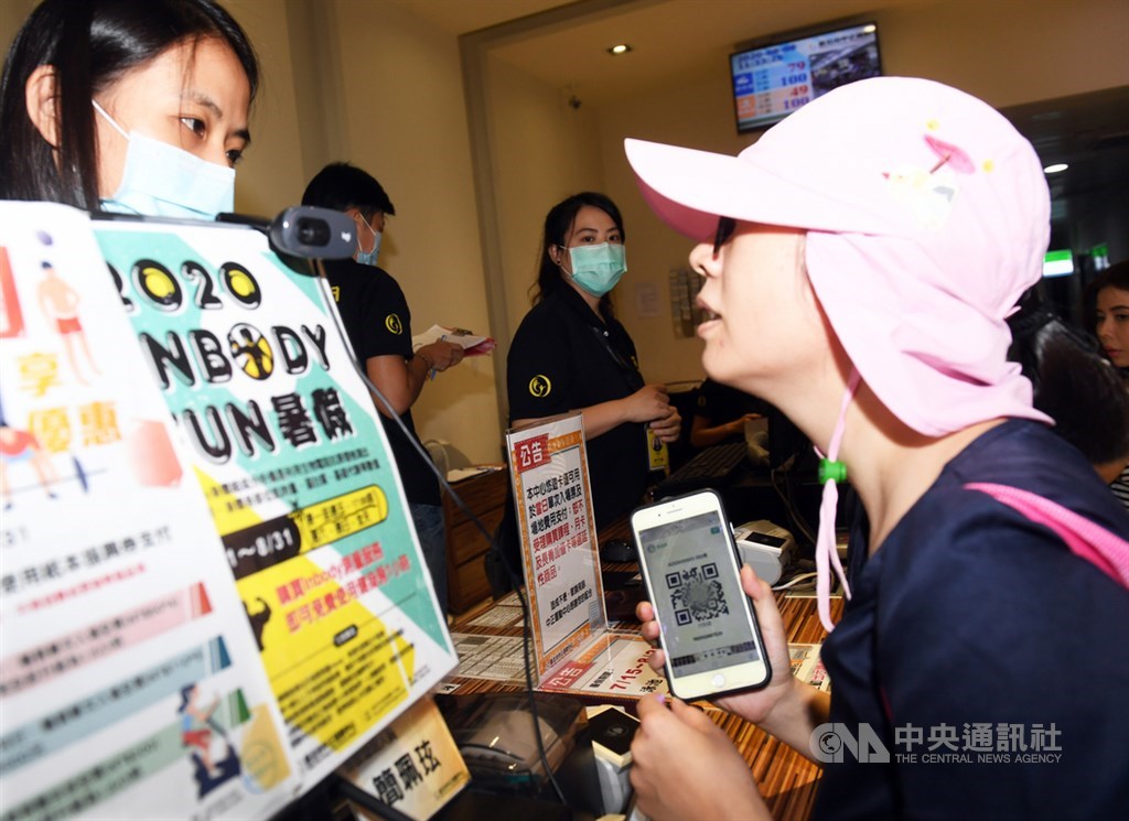 由體育署發放400萬份面額新台幣500元的動滋券正式啟用,有中籤民眾8日前往台北市中正運動中心,拿著手機向櫃檯服務人員詢問使用方法。中央社記者施宗暉攝 109年8月8日