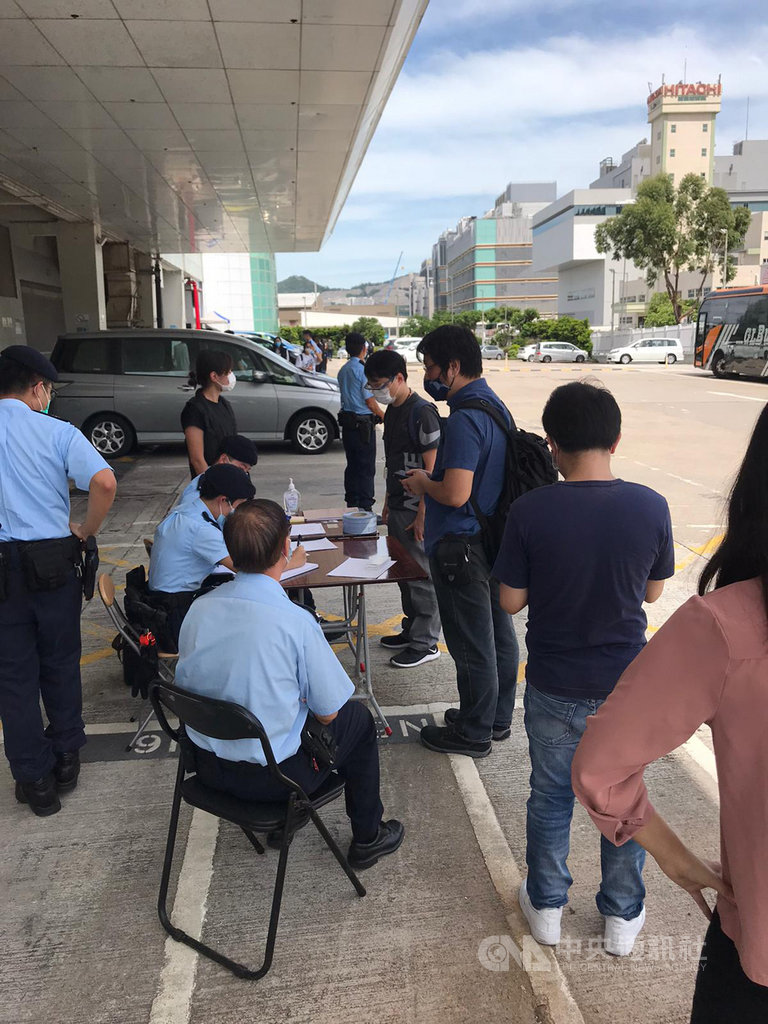 香港警方10日上午派遣大批人員到蘋果日報搜證,據信行動涉及執行港區國安法。圖為警員正在核實蘋果日報員工身分。(讀者提供)中央社記者張謙香港傳真 109年8月10日