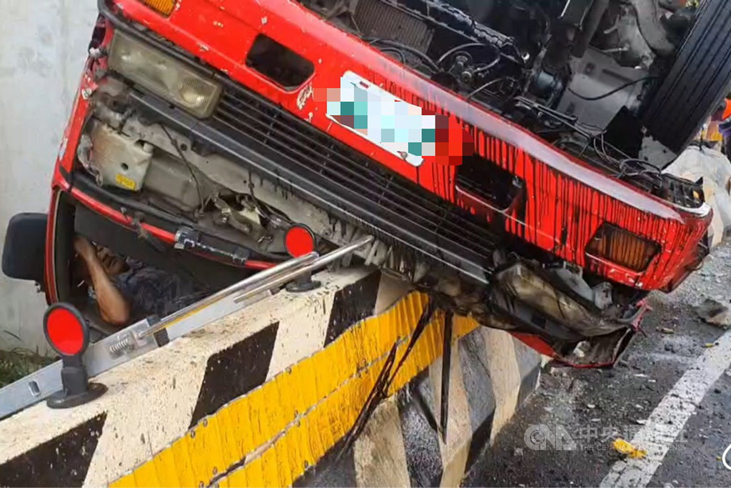 桃園市蘆竹區仁愛路三段高鐵橋下11日上午發生貨車翻覆事故,一輛貨車失控撞上分隔島,並翻覆掛在分隔島上,消防局獲報立即前往搶救。(桃園市政府消防局提供)中央社記者吳睿騏桃園傳真 109年8月11日