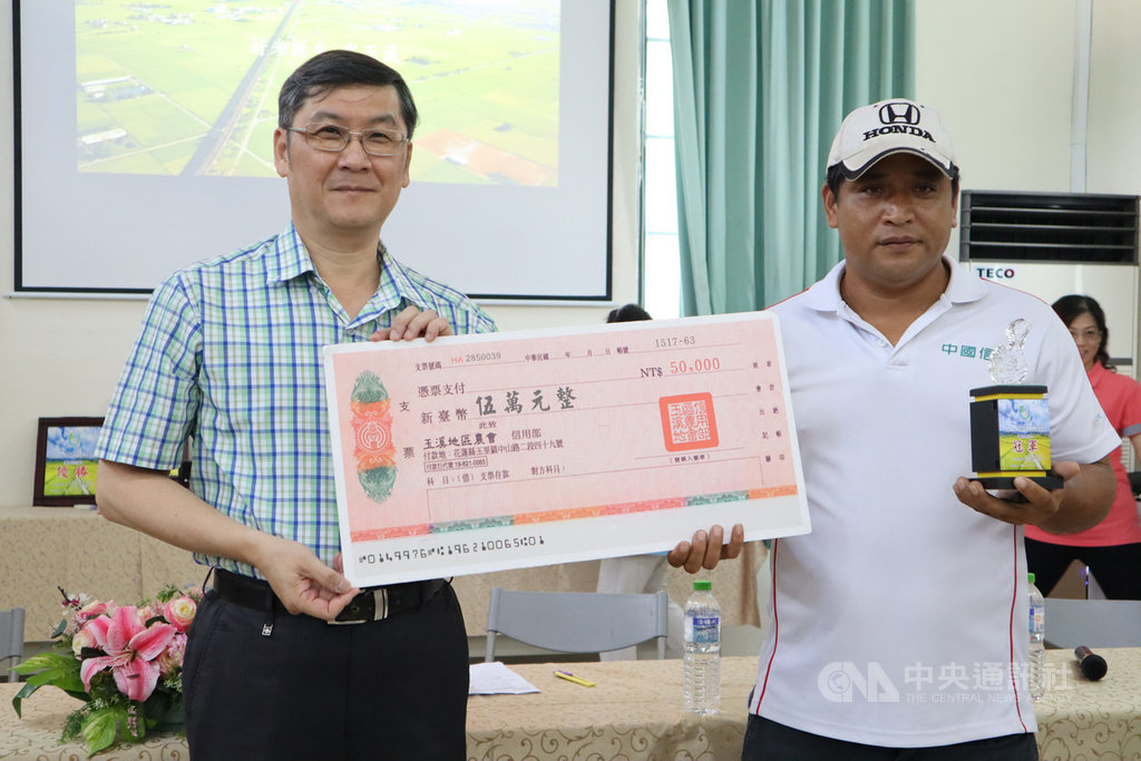 花蓮玉溪地區農會12日在農會推廣教育中心舉辦109年一期台灣稻米達人冠軍賽鄉鎮賽食味官能評鑑暨頒獎活動。農糧署東區分署副分署長陳吉村(左)頒發獎金與獎杯給有機米組冠軍楊朝富(右)。中央社記者李先鳳攝 109年8月12日