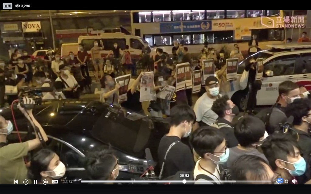 香港市民12日凌晨在旺角警署外舉起蘋果日報並高喊「撐蘋果,撐到底」以示支持黎智英。(圖取自facebook.com/standnewshk)