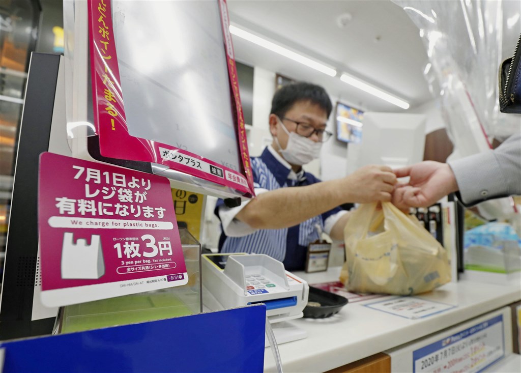日本從7月1日起實施塑膠購物袋收費新制後,購物網站的塑膠袋銷售量,卻意外成長3倍。圖為東京一間羅森便利商店櫃台標示塑膠購物袋收費新制。(共同社)