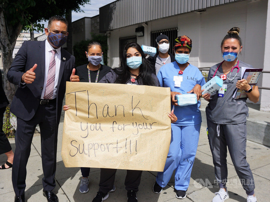 洛杉磯台美商會13日捐5萬片口罩給洛杉磯社區醫院(Los Angeles Community Hospital)。醫護人員出門相迎,拿手寫的海報致謝。中央社記者林宏翰洛杉磯攝 109年8月14日