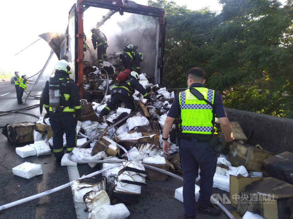 一輛載滿防護隔離衣的大貨車14日上午6時許在國道1號南屯路段突然起火,台中市消防局出動人車前往搶救,車上3人都及時下車避難,雖火勢迅速撲滅,但隔離衣搶救不及全數燒毀。(台中市消防局提供)中央社記者郝雪卿傳真 109年8月14日