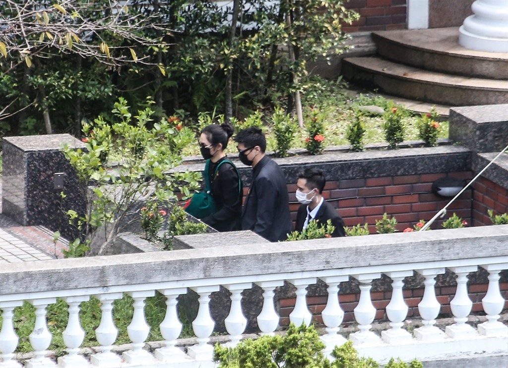 已故前總統李登輝14日中午在台北市第二殯儀館完成火化後,由孫女李坤儀(左)代表捧著骨灰,下午返抵翠山莊。中央社記者吳家昇攝 109年8月14日