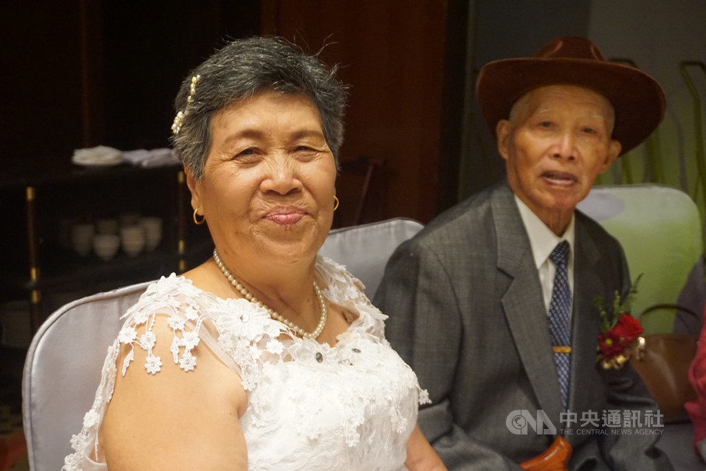高齡89歲的周達(右)15日再次穿上西裝、打起領帶,與重披白紗的妻子楊真珠(左)出席金門縣政府金婚、鑽石婚表揚活動,夫妻倆笑得幸福。中央社記者黃慧敏攝 109年8月15日