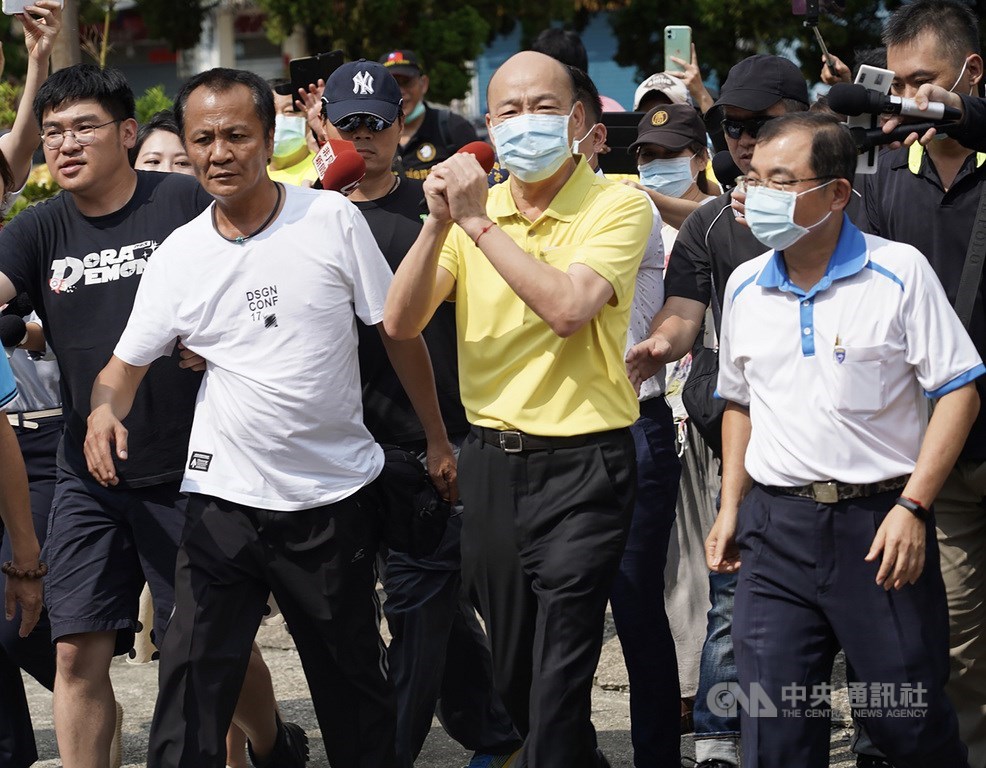 前高雄市長韓國瑜(前中)15日下午在國民黨籍高雄市議員王耀裕(前右)等人陪同下,前往林園區普願寺為第3屆高雄市長補選投票;面對現場大批媒體,韓國瑜拱手致意。中央社記者董俊志攝 109年8月15日