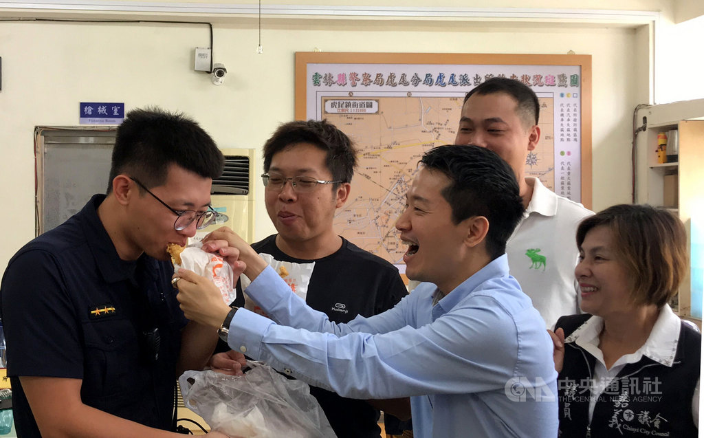 民進黨立委何志偉(前右2)17日在嘉義市議員黃露慧(前右1)等人陪同下到雲林縣虎尾警分局,兌現承諾贈送200份雞排給員警,感謝警方及時破案,未讓價值約3.7億的偽造振興三倍券流入市面。中央社記者姜宜菁攝 109年8月17日