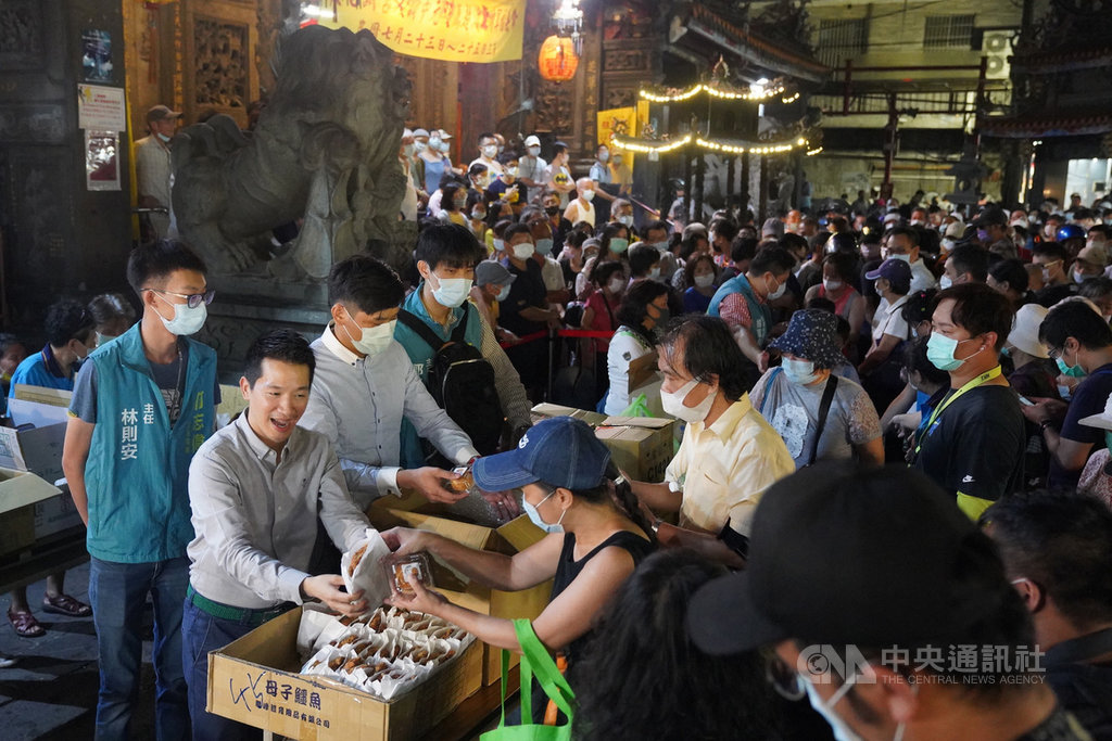 警方日前破獲假造三倍券,民進黨籍立委何志偉(前左灰衣者)21日晚間兌現承諾,選在台北士林慈諴宮免費發放1200份雞排,吸引大批民眾排隊領取。中央社記者徐肇昌攝 109年8月21日