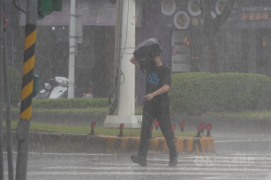 中央氣象局表示，西南風增強，易有短時強降雨。民眾27日中午在北市街頭遇到突如其來的大雨，以包包遮雨加快腳步過馬路。中央社記者徐肇昌攝　109年8月27日