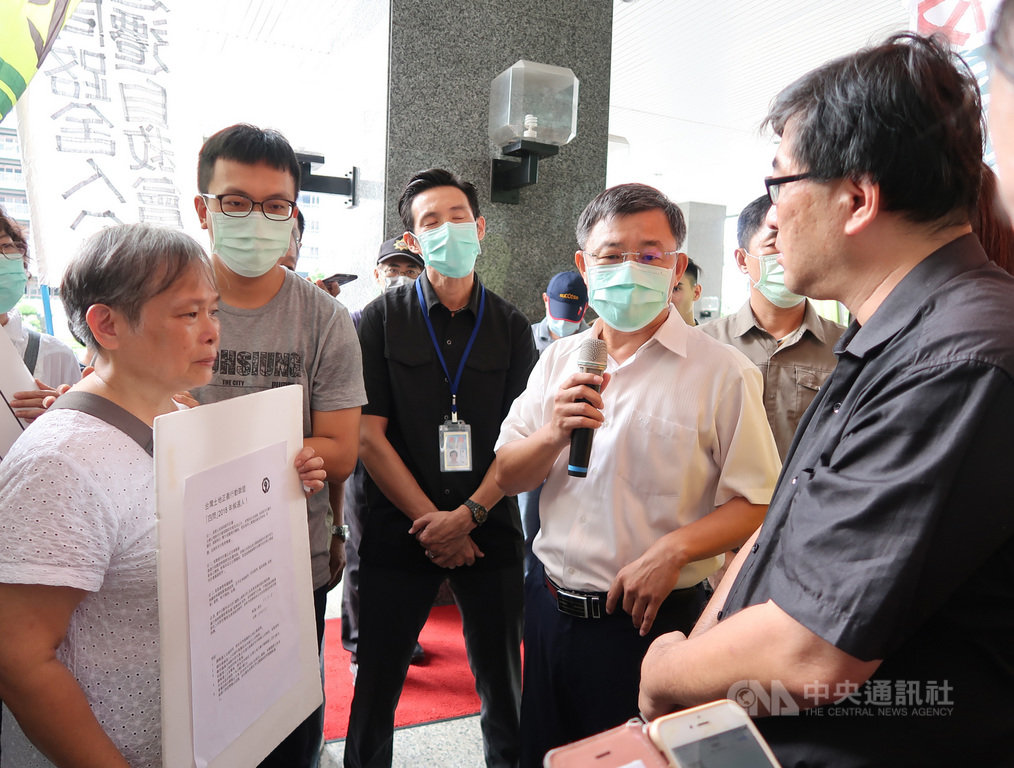 鳳山鐵路地下化反重劃自救會成員3日到高雄市政府前抗議市府6年來未盡溝通還迫遷阻路;市府副祕書長王啟川(右2)出面接下民眾陳情書,並允諾在溝通前不強拆、會確保居民道路暢通。中央社記者王淑芬攝 109年9月3日