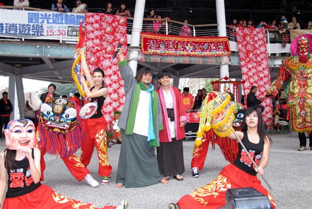 歌手嚴詠能(手舉麥克風者)民國102年在高雄市真愛碼頭舉辦婚禮,偕新娘陳玟勳一起表演「眾神護台灣」。(中央社檔案照片)