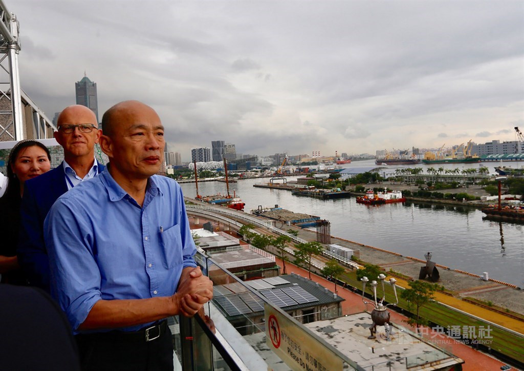 高雄市長陳其邁上任後責付團隊檢視政策,市府研考會初步確定太平島開挖石油、興建愛情摩天輪及賽車「不可行」。圖為2019年8月時任高雄市長韓國瑜(前)帶領廠商到城市商旅真愛館頂樓,一同勘查愛情摩天輪可能興建地。(中央社檔案照片)