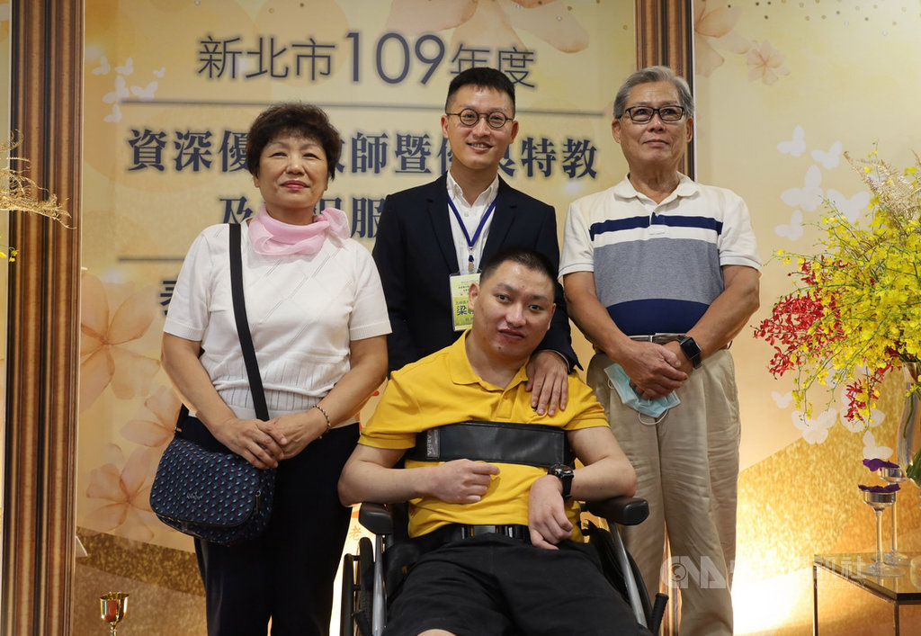 新北市10日表揚資深優良教師暨優良特教及教保服務人員,五峰國中教師梁禮昇(後中)協助學生適應生活並融入社會,獲優良特教人員肯定,與父母及腦麻弟弟一起出席表揚大會,分享喜悅。中央社記者黃旭昇新北市攝 109年9月10日