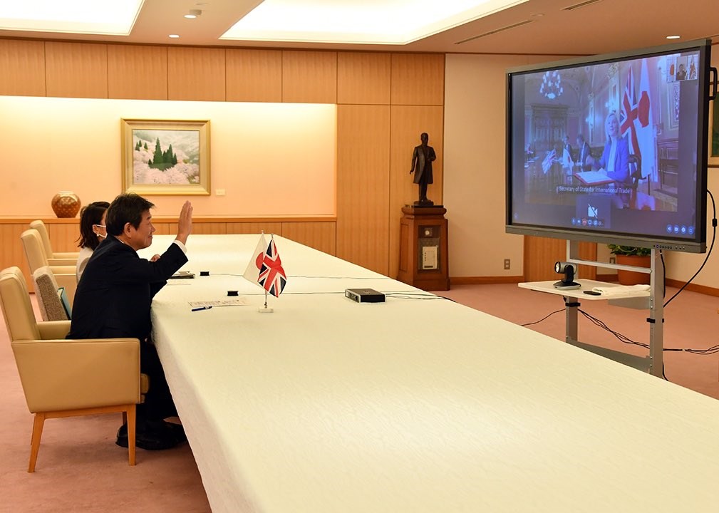 日本外務大臣茂木敏充(前)與英國國際貿易大臣特拉斯(螢幕上)11日舉行視訊會議,簽訂自由貿易協定(FTA),這是英國正式脫歐以來,首次簽署的重大貿易協定。(圖取自twitter.com/moteging)