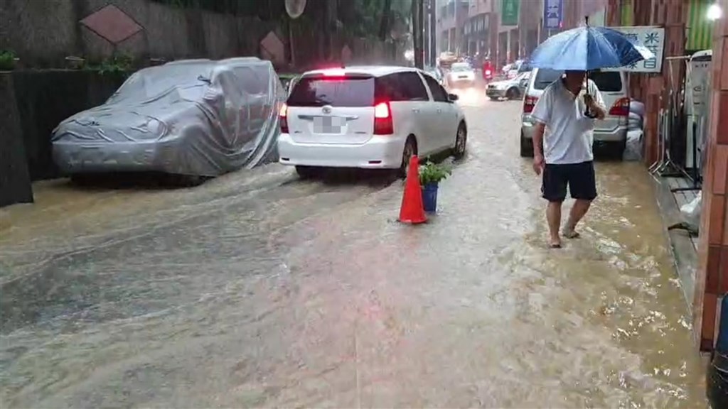基隆市12日下午雷聲大作、伴隨強降雨,中和路一度水淹達腳踝,有店家拿出三角錐擺在路中間,提醒來往車輛減速慢行。(讀者提供)中央社記者王朝鈺傳真 109年9月12日