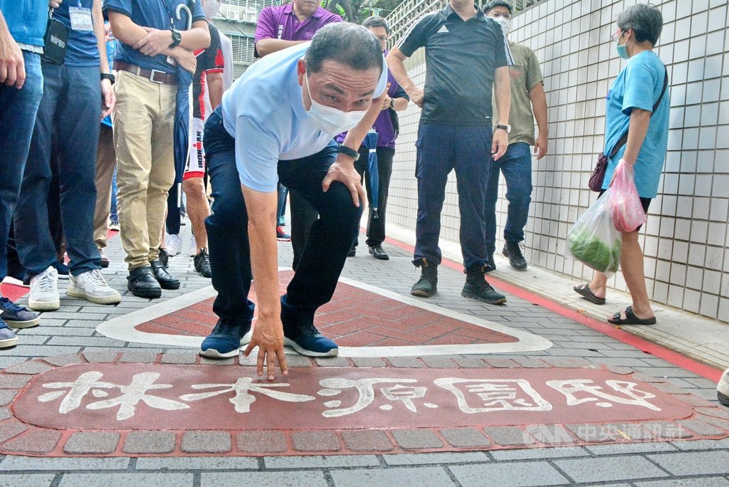 新北市長侯友宜(前)13日視察板橋林家花園周邊人行環境及景觀改善工程,親自走一段文昌街的人行道,對於拆除文昌街石板路,改以壓花防滑瀝青鋪面,侯友宜表示滿意防滑效果。中央社記者黃旭昇新北攝 109年9月13日