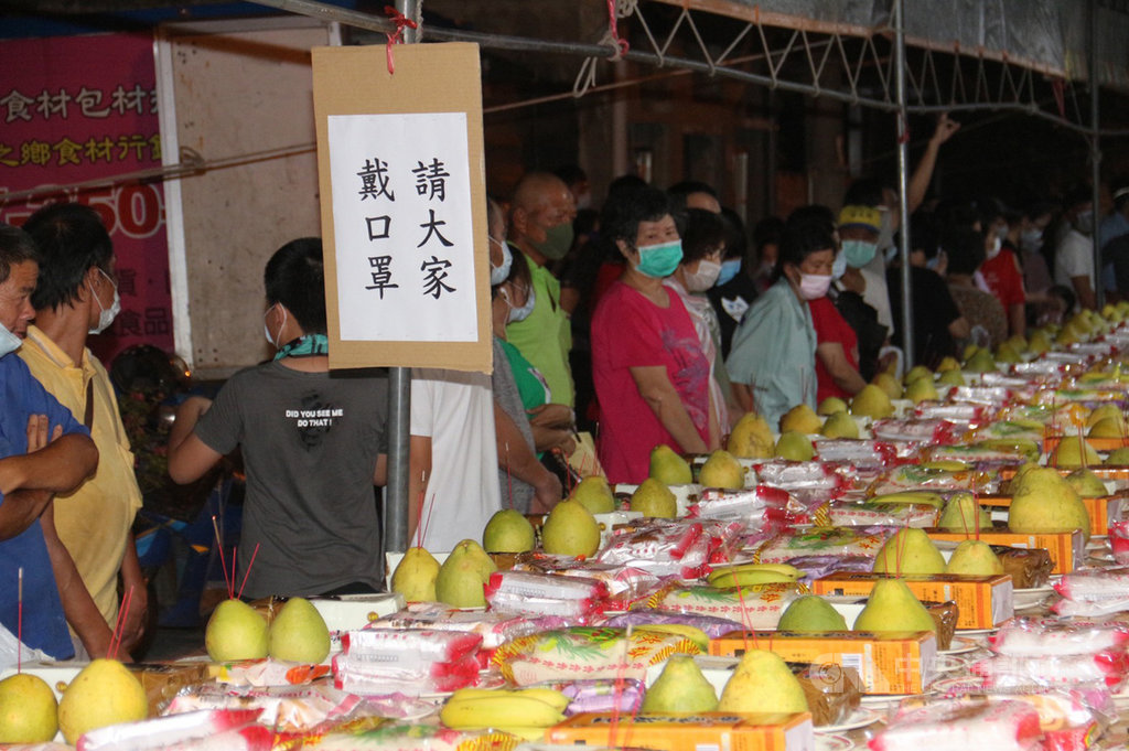 苗栗縣銅鑼鄉五福廟13日晚間舉辦普渡法會,法會圓滿結束後,開放民眾免費索取桌上供品,為響應防疫政策,廟方要求民眾戴口罩才能參與。中央社記者管瑞平攝 109年9月13日