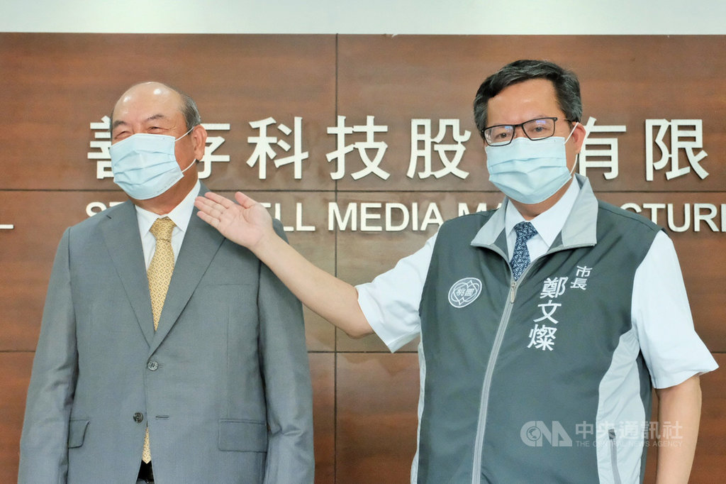 桃園市長鄭文燦(右)14日上午參訪善存科技口罩廠,與善存科技董事長阮登發(左)試戴有防偽雙鋼印的口罩。鄭文燦表示,市府除了列冊管理口罩工廠,針對產地疑慮,也會加強源頭、流通及末端出售點的管理與稽查。中央社記者吳睿騏桃園攝 109年9月14日