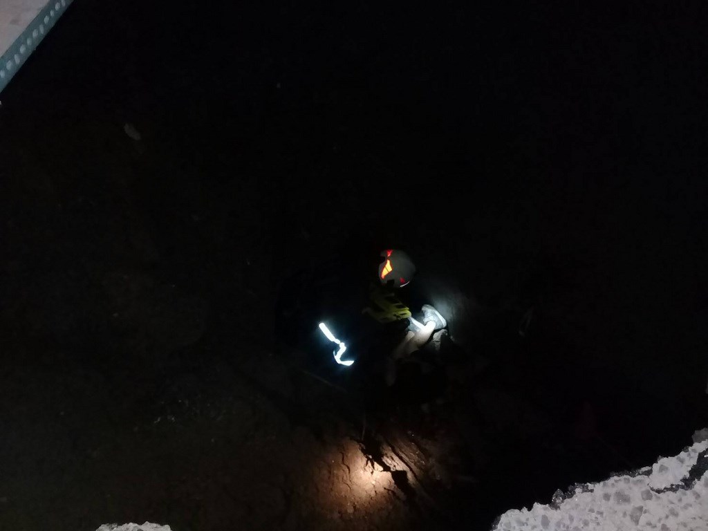 基隆市正濱國小資源回收室疑因地面下方涵管破裂導致地基被淘空,不知情的王姓學童入內意外墜落7公尺深坑洞,消防員從10幾公尺外的後方涵洞入內搶救,將王童搬上長背板從涵洞救出。(讀者提供)中央社記者王朝鈺傳真 109年9月15日