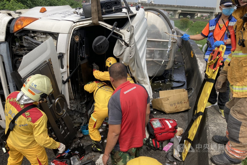 一輛裝載棕櫚油的槽車15日下午行經台86線道路東向仁德系統匯國道1號北上入口匝道時翻覆,駕駛手腳骨折一度受困,由消防人員救出送醫。(讀者提供)中央社記者楊思瑞台南傳真 109年9月15日