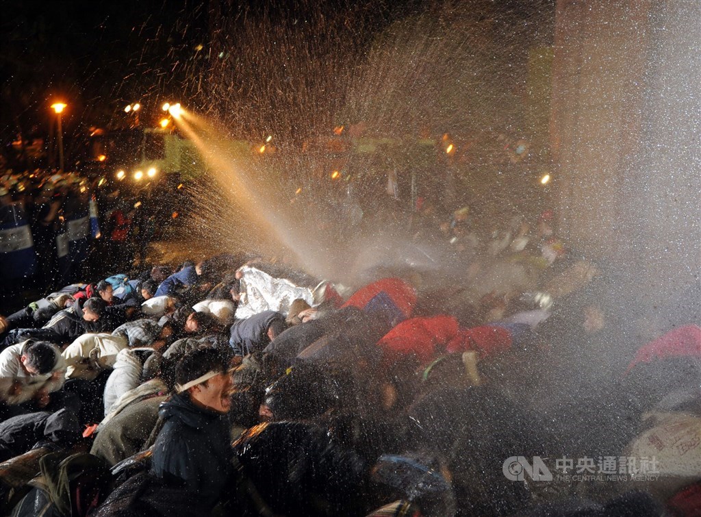 群眾不滿太陽花學運期間在行政院前靜坐遭驅離致傷等,自訴前總統馬英九、前行政院長江宜樺等人涉殺人未遂等罪,台北地方法院15日判決馬英九等人無罪。圖為2014年3月24日反服貿民眾遭警方以水柱驅離。(中央社檔案照片)