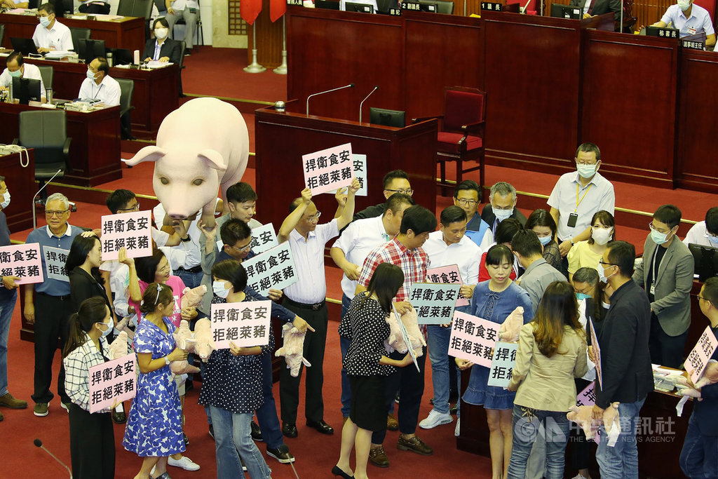 台北市長柯文哲17日下午赴台北市議會進行施政報告,大批議員高舉「捍衛食安,拒絕萊豬」標語,並扛著大豬公模型包圍柯文哲座位表達訴求。中央社記者郭日曉攝 109年9月17日