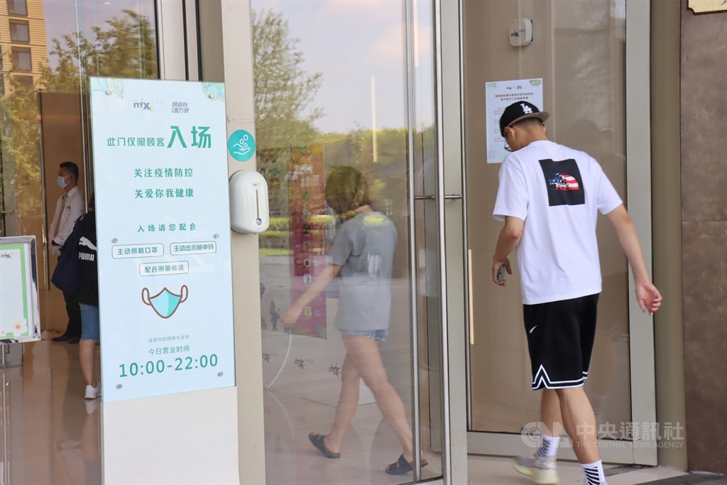 中國傳染病學專家鍾南山18日表示,疫情到2021年春天可能會繼續存在或發展。圖為中國上海一家商場公告要求戴口罩或出示健康碼。(中央社檔案照片)