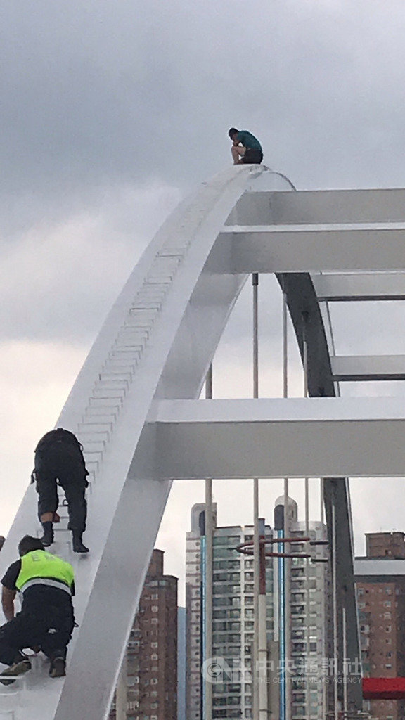 新北市八里區18日下午有1名男子不明原因爬上關渡橋頂,並企圖跳水,消防局獲報出動人車、船艇、升降機救援。(請珍惜生命。自殺防治專線(24小時):0800-788-995;生命線:1995。)(民眾提供)中央社記者黃旭昇新北傳真 109年9月18日