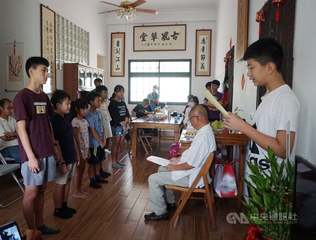 邁入第5年的金門古風小學堂19日舉行「書」字輩拜師典禮,本屆6名學生遵循古禮向老師倪振金(右坐者白衣)拜師,將展開為期1年的學習。中央社記者黃慧敏攝 109年9月19日
