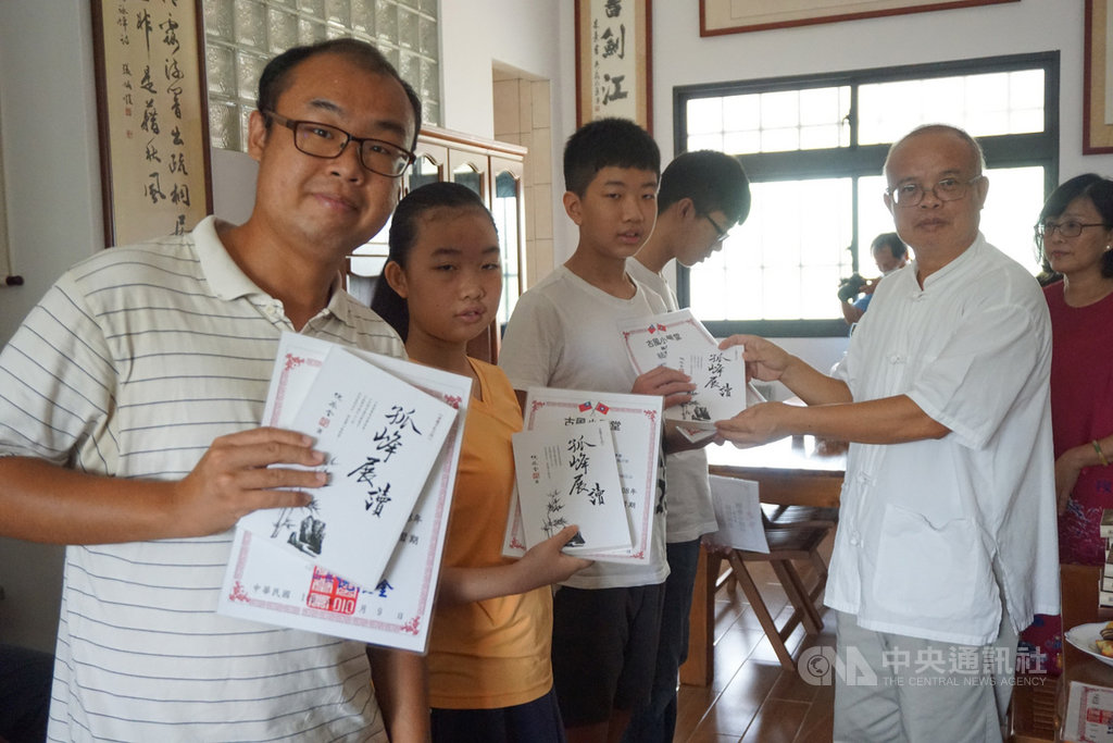 金門古風小學堂19日舉行「義」字輩謝師典禮,老師倪振金(前右)親自頒發結業證書並贈書給學員們。中央社記者黃慧敏攝 109年9月19日