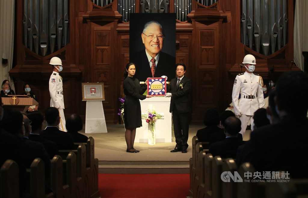 前總統李登輝追思告別禮拜19日在淡水真理大學大禮拜堂舉行,會場進行贈旗儀式,副總統賴清德(中右)致贈覆棺國旗給家屬,由孫女李坤儀(中左)代表接受。中央社記者張新偉攝 109年9月19日