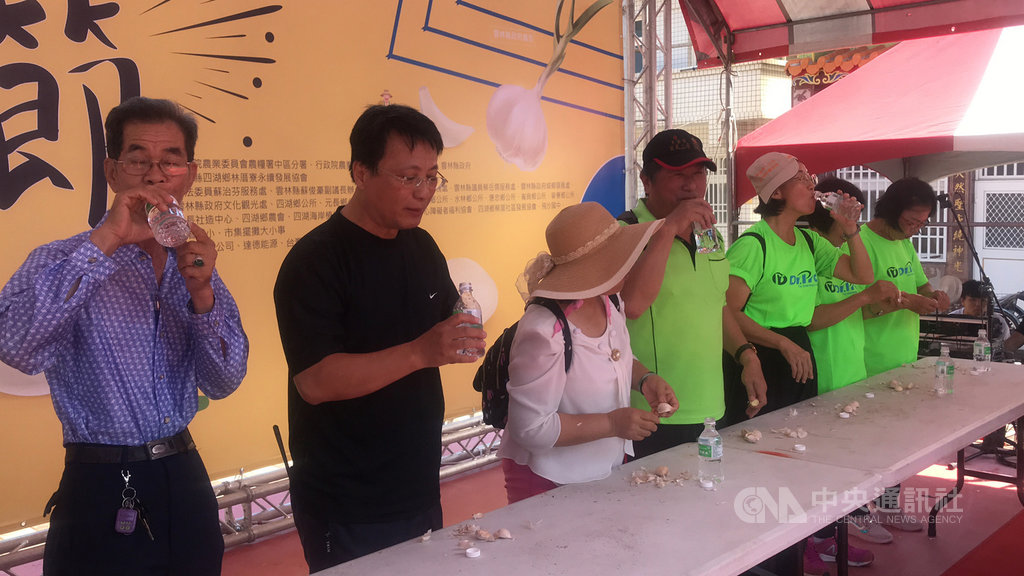 雲林縣四湖鄉林厝寮永續發展協會19日舉辦2020裝蒜節,不少民眾前來挑戰吃蒜比賽,不過蒜頭的辛辣讓參賽者們直呼受不了,頻頻喝水緩解。 中央社記者姜宜菁攝 109年9月19日
