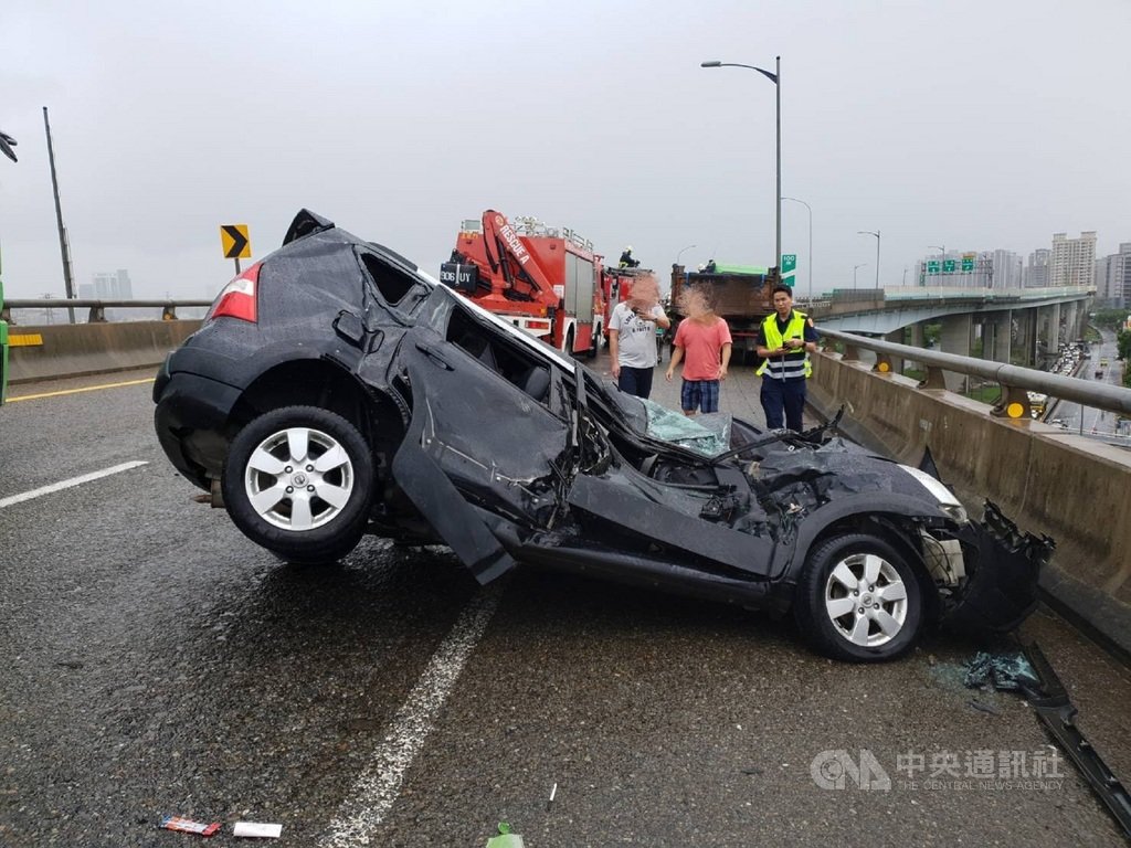 一輛砂石車20日行經台64線往新店方向9.2公里處,疑因天雨路滑撞擊一輛自小客車,小客車的車頭幾乎被壓扁,車體嚴重擠壓變形,警消獲報到場將車上一家3口救出,受傷送醫但無生命危險。(翻攝畫面)中央社記者王鴻國傳真 109年9月20日