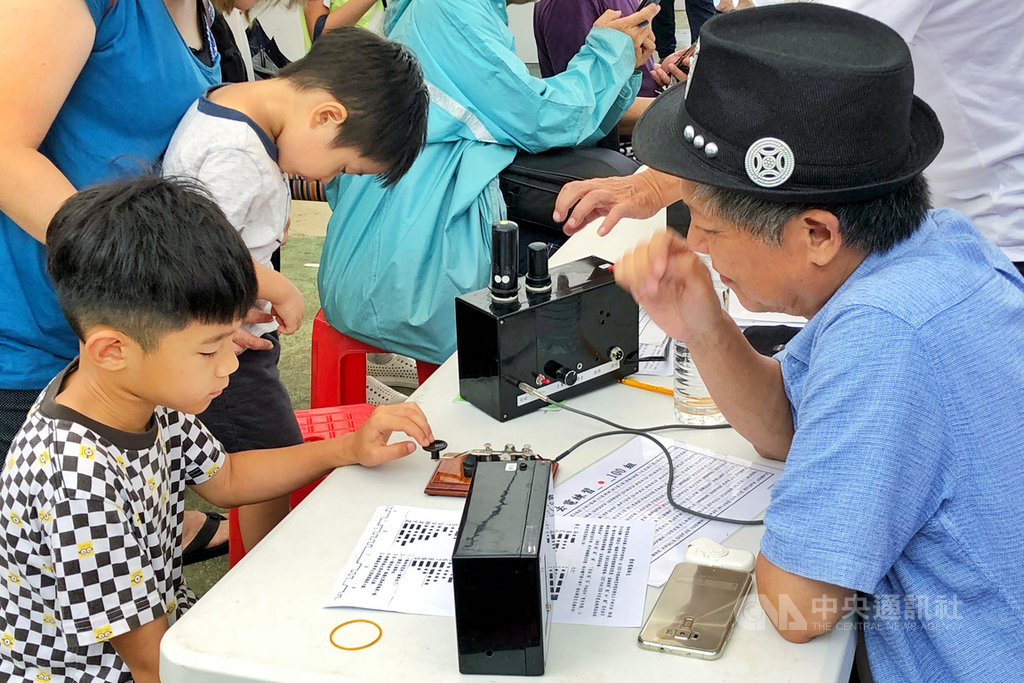 桃園市龍岡米干節18日起在龍岡大操場舉行,摩斯密碼體驗20日吸引大小朋友參與,退休情報人員現場教導民眾簡單的密碼,還透過摩斯密碼打出自己的英文名字。中央社記者吳睿騏桃園攝 109年9月20日