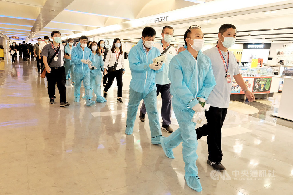 在移民署和越南經濟文化辦事處的努力下,越南21日安排專機來台接返移民署收容所內的289名逾期居留外籍移工,由於人數眾多,移民署將他們分別安排在2處候機室,分批穿上防護衣、戴上口罩等,並在量測體溫後才可登機。中央社記者吳睿騏桃園機場攝 109年9月21日