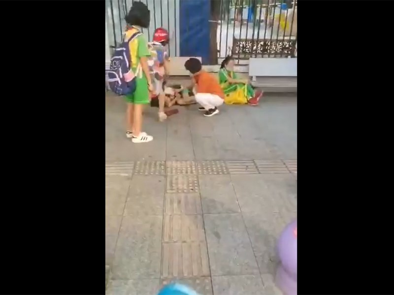 廣東省廣州市番禺區的一所幼兒園附近21日上午發生一起砍人案,從網路上流傳的影片可見,2名背著書包的學生倒臥在地,地面有血跡。(圖取自twitter.com/wuwenhang)