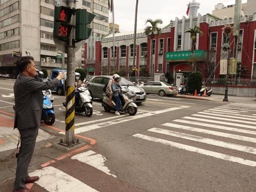 2019年3月13日,金尚浩(左)站在趙明河義舉街頭,手指趙明河義舉前所在地。 (金尚浩提供)