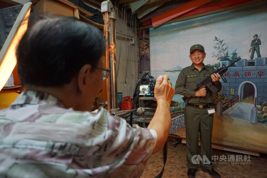 金門縣長楊鎮浯(後)24日穿上草綠色軍服,手持步槍,在傳統照相館老闆李國明(前)掌鏡下,展現英姿,邀請曾在金門服役的老兵重返英雄島。中央社記者黃慧敏攝 109年9月24日