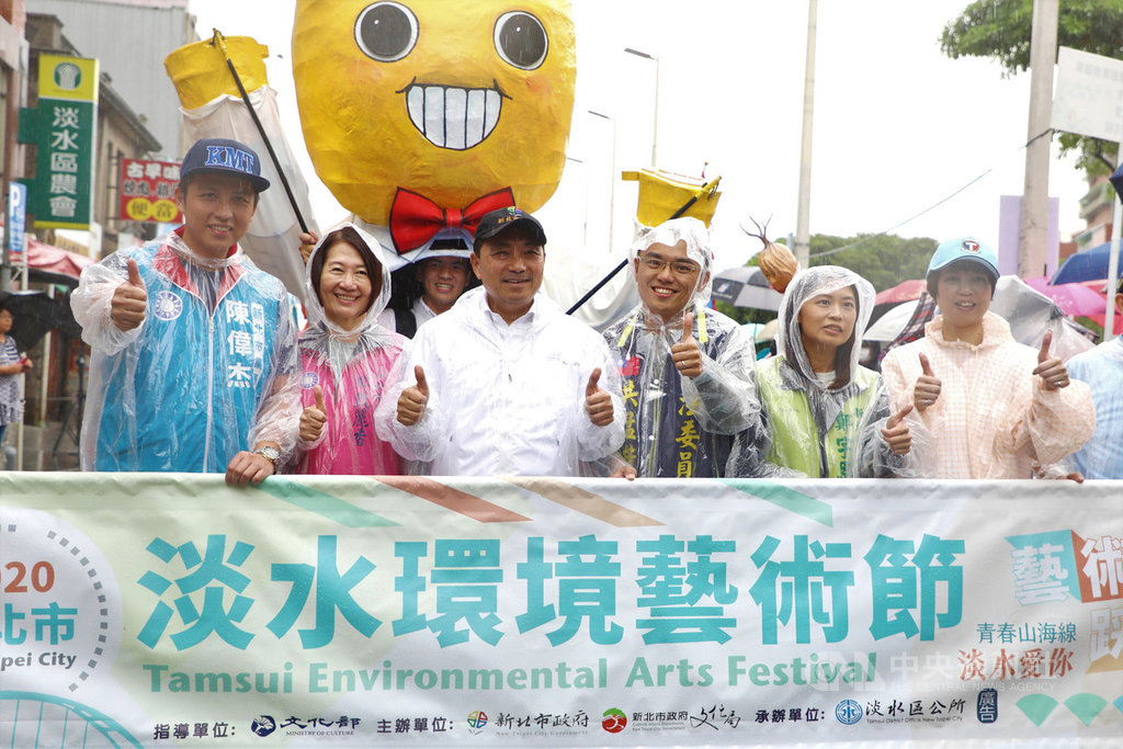 淡水環境藝術節踩街活動27日在淡水老街展開,新北市長侯友宜(左3)冒雨參與遊行,現場氣氛熱烈。中央社記者王鴻國攝 109年9月27日