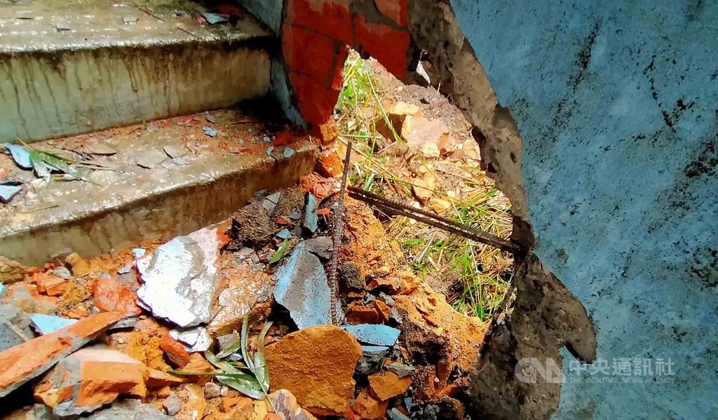 基隆連日大雨造成土石鬆動,中山一路241巷一處山壁27日上午崩落,大石滾落砸進住家,不僅1樓房間被大石撞破大洞,2樓屋外通往3樓頂棚的水泥樓梯護牆也受損。中央社記者王朝鈺攝 109年9月27日