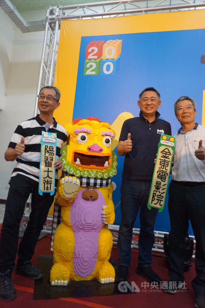 台灣唯一國際樂高認證師黃彥智(左)為金門打造全新意象的風獅爺,27日在金沙鎮金東電影院亮相,這座風獅爺的披風是金門特有的黑白相間格子布「花帔」造型,令人驚豔。右2為金門縣長楊鎮浯。中央社記者黃慧敏攝 109年9月27日