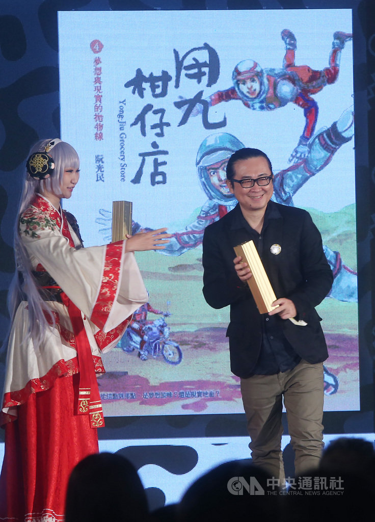 第11屆金漫獎頒獎典禮28日下午在台北登場,漫畫家阮光民(右)以作品「用九柑仔店1-5」獲「跨域應用獎」,並以「天橋上的魔術師圖像版:阮光民卷」拿下「年度漫畫獎」,成雙料贏家。中央社記者鄭傑文攝 109年9月28日