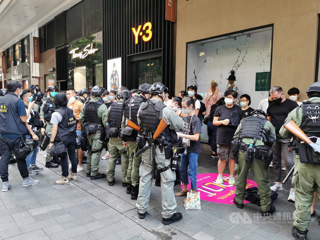 香港民眾於1日中共建政71週年當天,在多區遊行,警方多次舉旗警告,並於下午4時許圍捕不願離去的示威者。圖為警方逐一檢查被捕人員的身分證。中央社記者張謙香港攝 109年10月1日