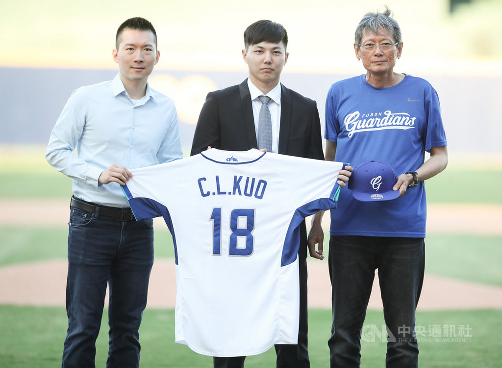 中職富邦悍將今年季中選秀第二輪選進旅日好手郭俊麟(中),1日在新莊球場舉辦加盟儀式,領隊蔡承儒(左)與顧問郭泰源(右)出席,拿著18號球衣合影。中央社記者張新偉攝 109年10月1日