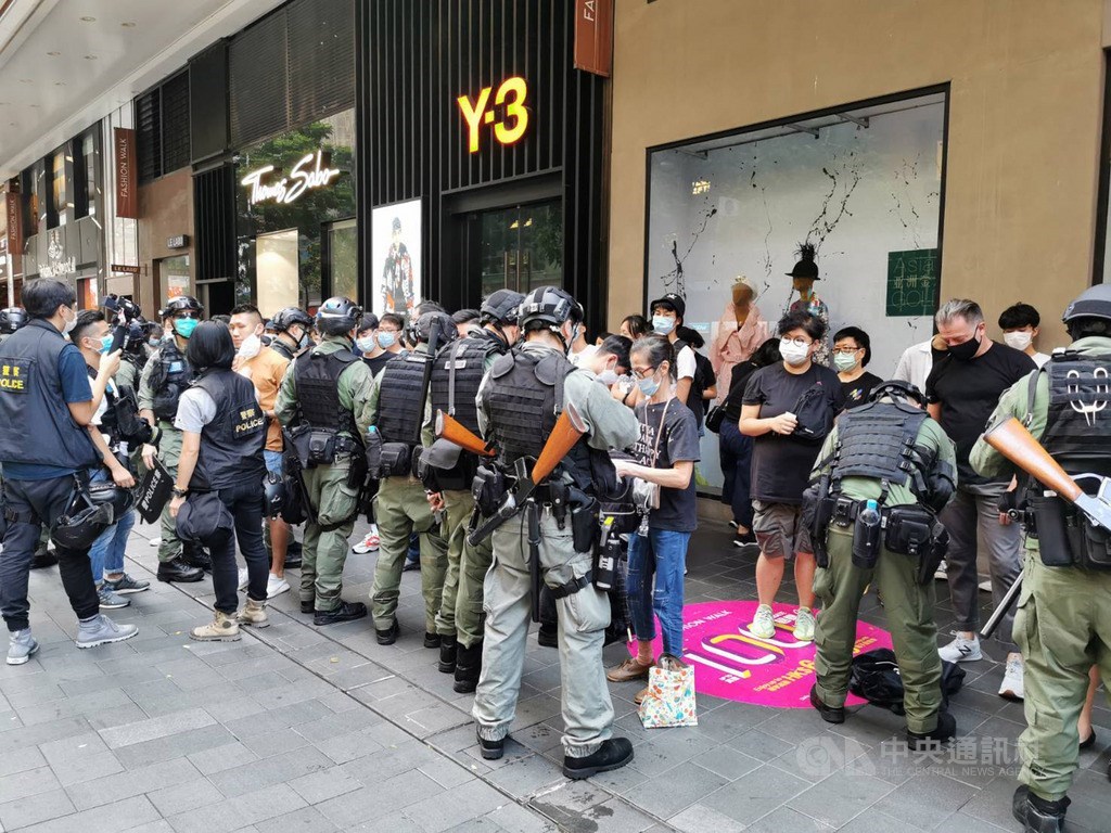 香港民眾於1日中共建政71週年當天,在多區遊行,警方多次舉旗警告,並於下午4時許圍捕不願離去的示威者。圖為警方逐一檢查被捕人員的身分證。中央社記者張謙香港攝 109年10月1日