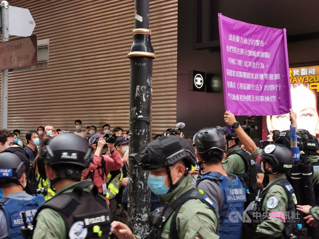 歐盟27國領導人1日高峰會後針對歐中關係發表聲明,強調嚴重關切中國人權狀況及香港情勢。圖為香港銅鑼灣一帶1日有示威者高叫「時代革命光復香港」口號,防暴警察舉起紫旗,警告他們已經違反國安法。中央社記者張謙香港攝 109年10月1日